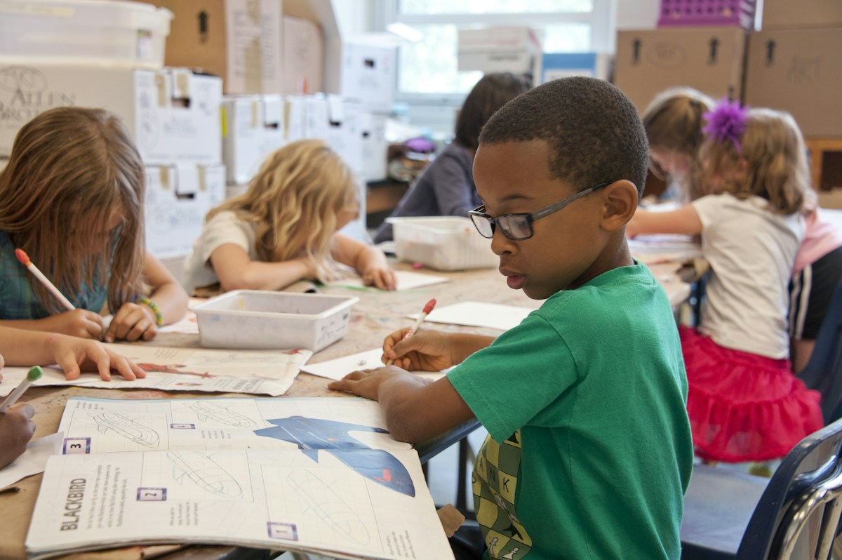 Children working on creative projects together at a classroom table